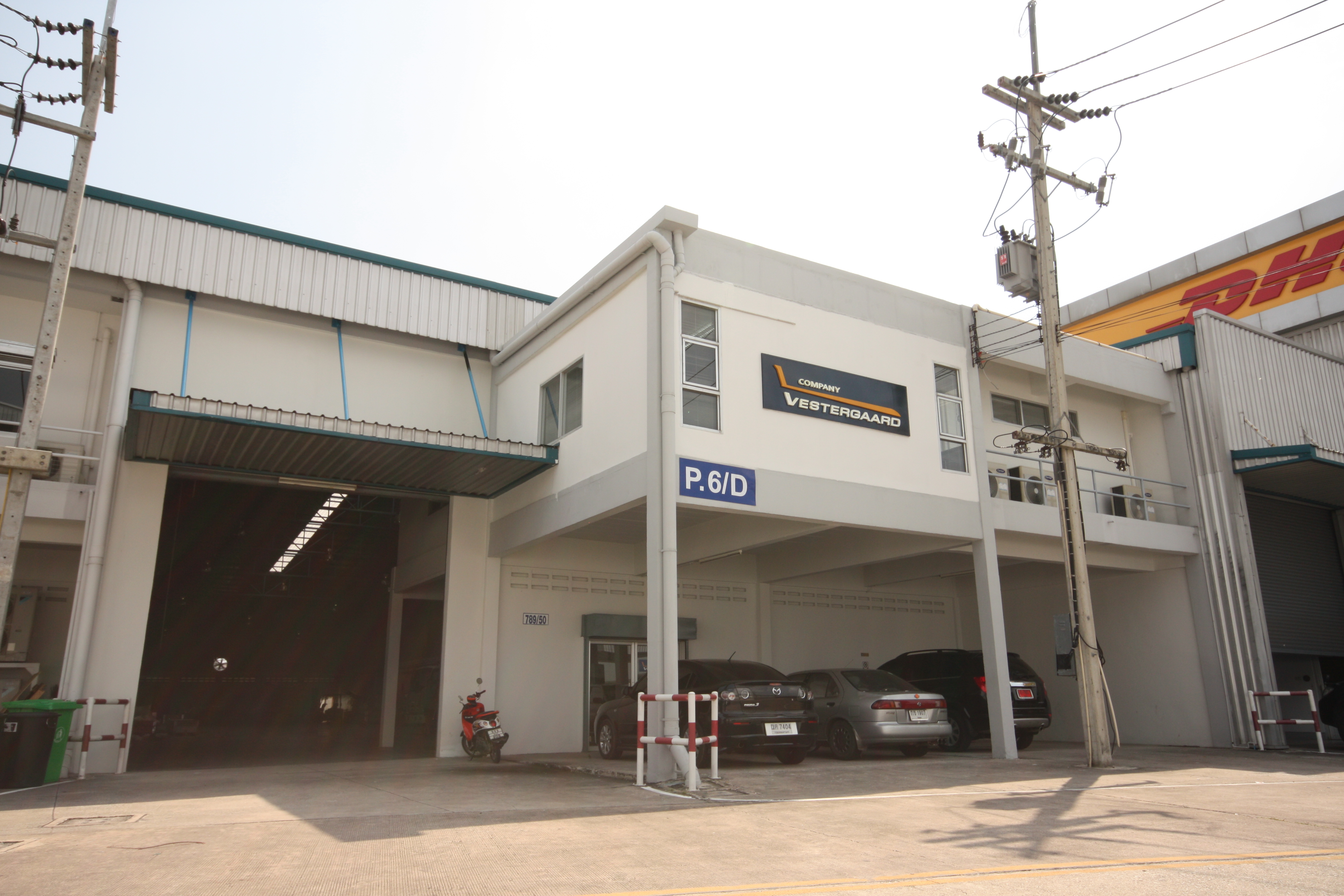 P&D building with vehicles parked outside, featuring a sign with "P&D" and a loading dock area.